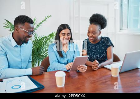 Young business woman explains to colleagues using tablet at office boardroom Stock Photo