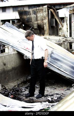 New Zealand Defense Minister Phil Goff, right, High Commissioner Brian  Sanders, center, and lawmaker Ron Mark take a first hand look at the damage  caused during the April 18 rioting and looting