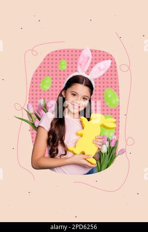 Photo postcard spring holiday happy easter cute girl hold paper yellow rabbit wear headband ears near fresh flowers isolated on pink background Stock Photo