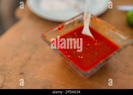 A small bowl of hot salsa made of chiltepin peppers, a wild variety of chili pepper, is seen placed on the table in a farm near Baviácora, Mexico. Stock Photo