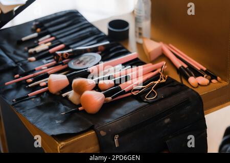 Makeup brushes and cosmetics on the table in the beauty salon.  PINK BLUSH STILL LIFE Stock Photo