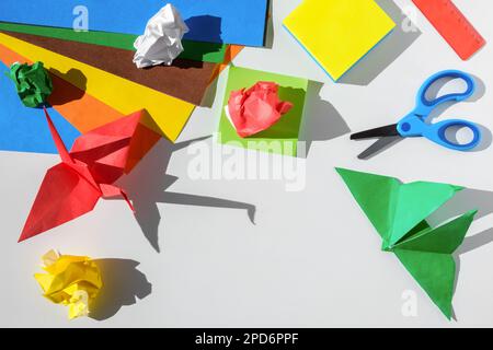 https://l450v.alamy.com/450v/2pd6ppf/paper-crafts-scissors-colored-paper-sheets-and-scraps-on-white-table-origami-children-working-place-preschooler-paper-artwork-and-craft-art-idea-2pd6ppf.jpg