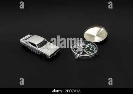 Concept for traveling. Need a guidance like compass or other navigation for traveling. A photo of a toy car and a compass, after some edits. Stock Photo