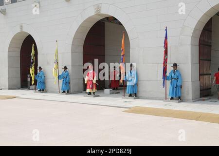 Guards in traditional Korean constumes near the entrance (Gwanghwamun Gate) of Gyeongbokgung palace in Seoul, South Korea Stock Photo