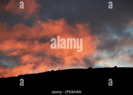 red sky at night a red cloudy setting sun sky above silhouette of a mountain ridge Lanzarote, Canary Islands, Spain Stock Photo