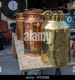 Three gold and copper polished cans at a flea market. Square frame. Stock Photo