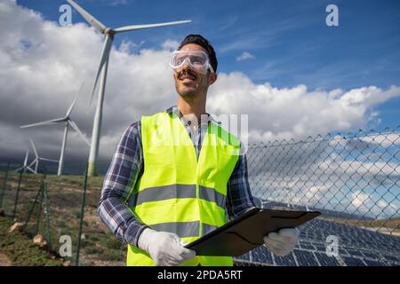An engineer in a solar power plant at work, confident and smiling successful person. Stock Photo