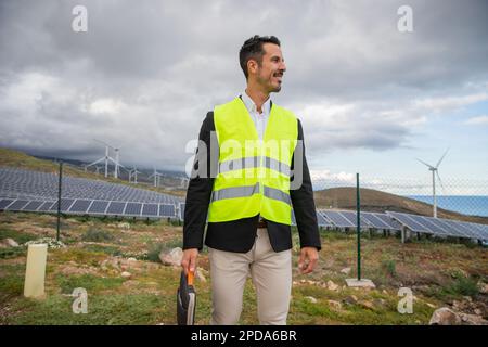 An engineer holds a laptop sleeve during an inspection at the solar power plant. Stock Photo