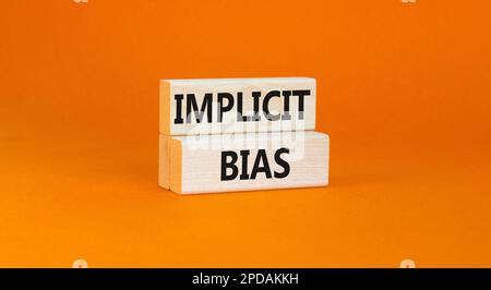 Implicit bias symbol. Concept words Implicit bias on wooden block. Beautiful orange table orange background. Business psychology implicit bias concept Stock Photo