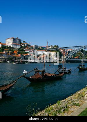 Wooden boats (Rabelos) moored on the river Douro by Cais de Gaia overlooking the historic part of Porto, Ribeira and the Ponte Luis I, Portugal. Stock Photo