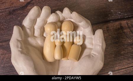 close up of womans cupped hands showing paper man family Stock Photo