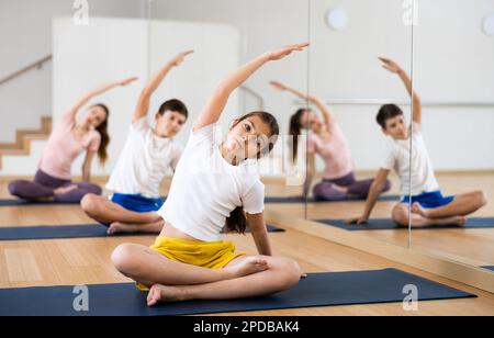 Girl doing lotus pose exercises in gym
