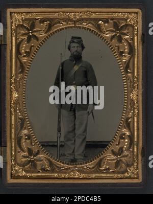 Private George H. Bannister of Company H, 13th New Hampshire Infantry Regiment in sack coat and forage cap with holstered bayonet, cartridge pouch, and bayoneted musket. Liljenquist Family Collection of Civil War Photographs , FAmbrotype/Tintype photograph filing series , pp/liljunion. Bannister, George H, -1864, United States, Army, New Hampshire Infantry Regiment, 13th (1862-1865), People, United States, History, Civil War, 1861-1865, Military personnel, Union, Soldiers, Union, 1860-1870, Military uniforms, Union, 1860-1870, Rifles, 1860-1870, Bayonets, 1860-1870. Stock Photo