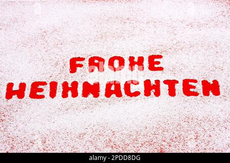 red writing Frohe Weihnachten, Merry Christmas, on snow Stock Photo