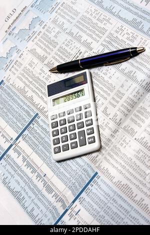 page with stock-market infos in a newspaper, calculator and ballpen Stock Photo