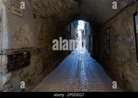 SOMMIERES, FRANCE - MARCH 4th, 2023: rue Cavalerie, a paved street in Sommières, Gard, South of France Stock Photo