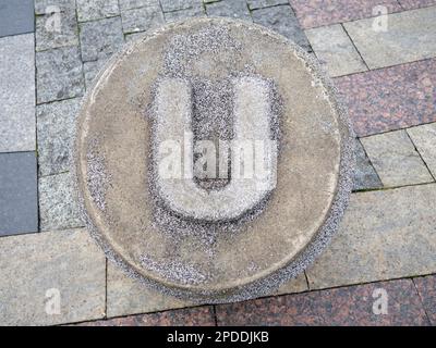 Letter U  made of stone. Carved letter U in concrete. Alphafit cast from concrete. The concept of the letter U. In the park Stock Photo