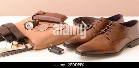 Set of stylish male clothes and accessories with car key and notebooks on table Stock Photo