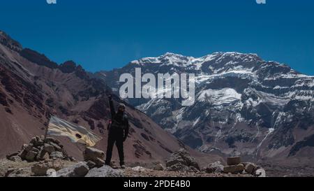 Young climber man with raised fist with Aconcagua mountain in the background on a sunny day Stock Photo