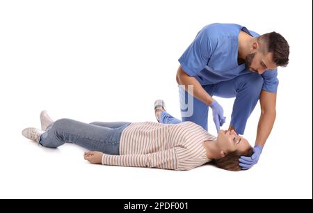 Doctor in uniform performing first aid on unconscious woman against white background Stock Photo