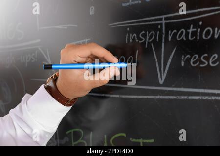 Business trainer with pen using interactive board, closeup Stock Photo