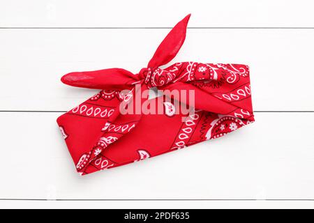 Tied red bandana with paisley pattern on white wooden table, top view Stock Photo