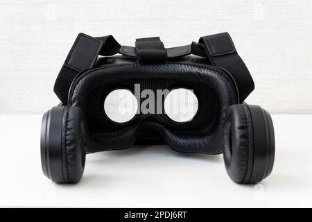 Virtual reality helmet on white background table. Black modern glasses for watching 360 degree videos for a smartphone. Stock Photo