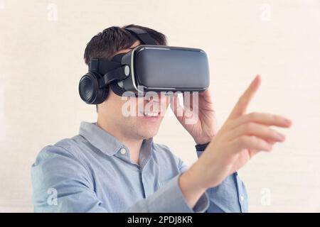Businessman using virtual reality glasses in office. Man in VR headset standing touching objects in digital simulation. Realistic 3d visualization, in Stock Photo