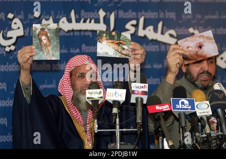 ** EDITORS NOTE GRAPHIC CONTENT ** Association of Muslim Scholars spokesman Abdul Salam al-Kubaisi, right, and an unidentified member of the association show undated pictures of allegedly tortured men, during a press conference in Baghdad, Iraq, in this Nov. 17, 2005 file photo. A torrent of bad news   rising soldier death tolls, suicide bombers, torture allegations   is riling America right now with the hard realities of Iraq. (AP Photo/Khalid Mohammed/File)