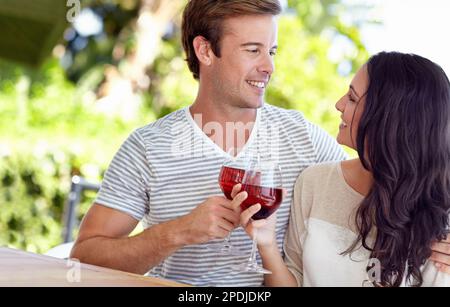 Cheers to us. A young couple drinking a glass of wine on their patio. Stock Photo