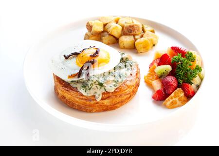 Florentine - creamy mix of chicken and spinach served in a danish pastry, topped with fried egg and sun-dried tomatoes. Stock Photo