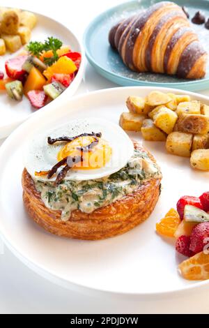 Florentine - creamy mix of chicken and spinach served in a danish pastry, topped with fried egg and sun-dried tomatoes. Stock Photo