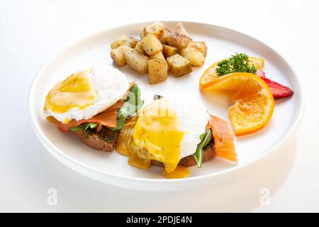 Salmon Benedict - poached eggs, hollandaise sauce, smoked salmon, pesto and rocket leaves served on ciabatta. Stock Photo