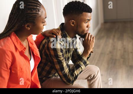 Sad african american couple sitting together in hall Stock Photo