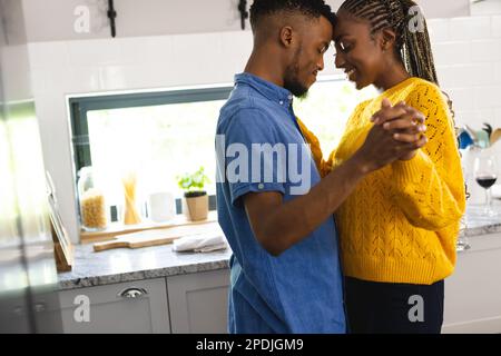 Happy african american couple dancing together in kitchen Stock Photo
