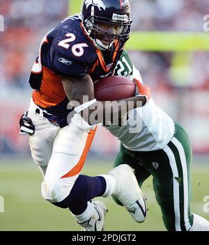 Tennessee Titans Keith Bulluck (53) attempts to tackle Denver Broncos  running back Tatum Bell (26) at Invesco Field at Mile High in Denver,  Colorado, Saturday, August 19, 2006, in NFL preseason action. (