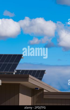 Solar panels on roof on a modern home with a blue cloudy sky background, Castlemaine, Victoria, Australia. Stock Photo