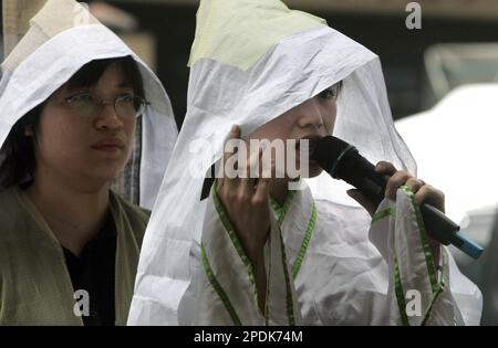 Draped in traditional Taiwanese funeral hood, a professional mourner of ...