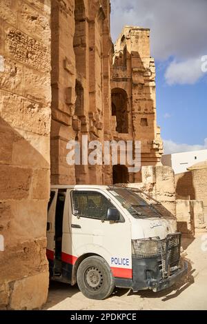 El Jem, Tunisia, January 10, 2023:Battered police car with protective bars between the pillars of the El Jem amphitheater Stock Photo