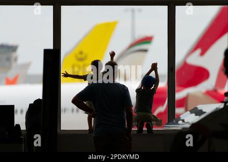 Children looking through the window while waiting at airport, Sydney, Australia. Stock Photo