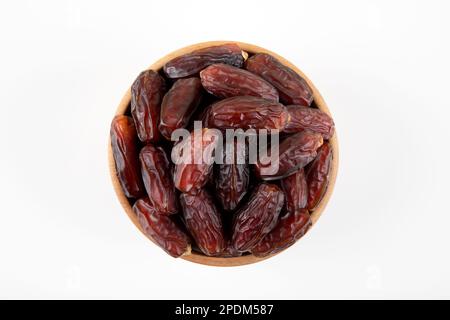 Date fruits in wooden bowl,on white background,top view Stock Photo