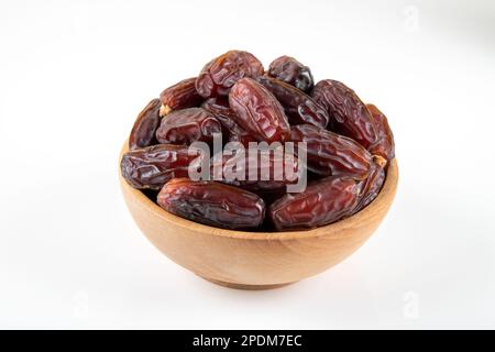 Date fruits in wooden bowl,on white background,top view Stock Photo