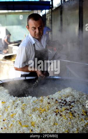 Giant cauldrons overflow with Uzbekistan's favorite rice dish at the Central Asian Plov center in Tashkent, Uzbekistan. Stock Photo