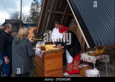 Local villagers selling Oscypek, a smoked cheese made of salted sheep milk exclusively in the Tatra Mountains region of Poland. Stock Photo