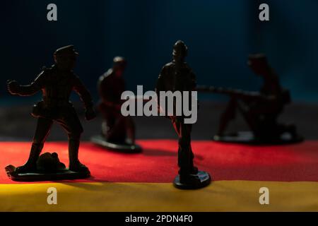 Small plastic soldiers stand on the flags of Germany close-up, army and war Stock Photo