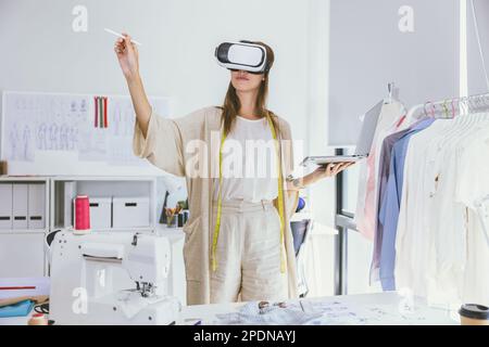 Costume designer using modern VR visual digital design technology in tailor studio Stock Photo