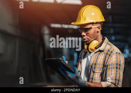 workshop male worker using online wireless tablet technology for computer aided design helping at work Stock Photo