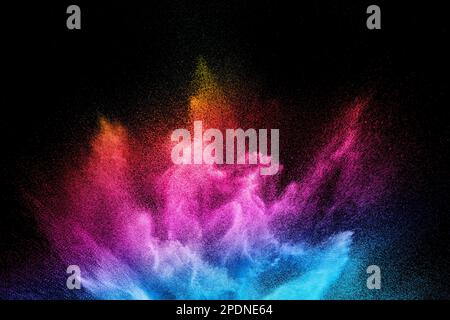 Multi colour powder explosion on black background. Launched colourful dust  particles splashing. Stock Photo