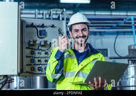 Portrait electricity worker hispanic engineer working in factory checking high voltage electrical power cabinet in factory. Stock Photo