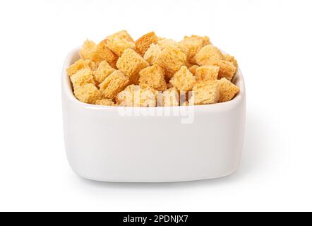 Crispy croutons in bowl isolated on white background with clipping path Stock Photo